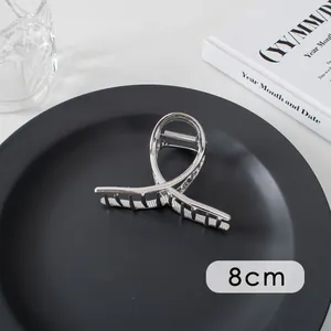 Silver large metal hair claw clip with 8cm measurement on a minimalist dark tray