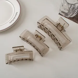 Set of three translucent grey claw clips in large, medium, and small sizes on a white plate