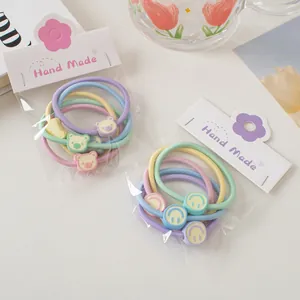 Détail d'élastiques à cheveux macaron avec ours mignons et sourires en emballage fait main