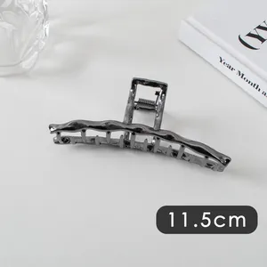 Detailed view of the 11.5cm large irregular wavy metal hair claw clip in dark grey