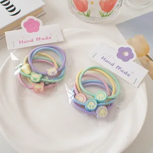 Détail d'élastiques à cheveux macaron à haute élasticité avec oursons et smileys