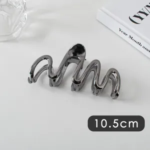 Detail view of a 10.5cm wave-shaped large gunmetal grey metallic hair claw clip