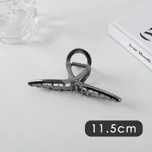 Detail showing an 11.5cm large dark grey metal hair claw clip with a sleek circular design