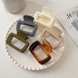 Minimalist square hair claw clips set in five colors on a decorative pearl tray