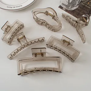 Set of six transparent grey geometric hair claws in minimalist acrylic and gold metal