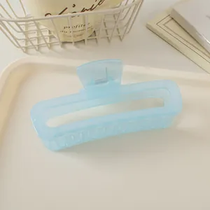 Détail d'une pince à cheveux rectangulaire bleu clair mat de 13cm sur un plateau chic