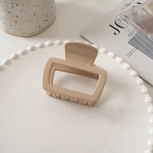 Macro shot of minimalist beige square hair claw clip on a decorative pearl tray