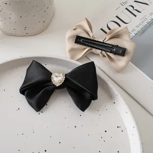 French vintage satin bow hair clips with heart rhinestone detail and champagne ribbon