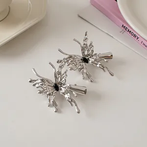 Detailed view of silver liquid metal butterfly hair clips with black stone accents