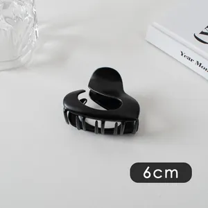 Detail view of a 6cm matte black heart-shaped hair claw clip with sleek fluid lines