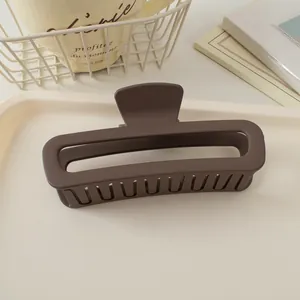 Détail d'une grande pince à cheveux carrée marron mat montrant une texture lisse