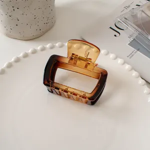 Detailed shot of amber gradient square hair claw clip on an elegant white tray