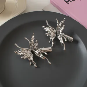 Macro detail of silver liquid metal butterfly hair clips with black centerpiece stone