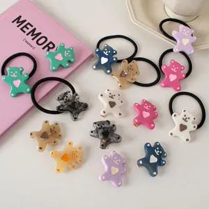 Detail shot of colorful bear hair clips and ties with heart design on a cozy background