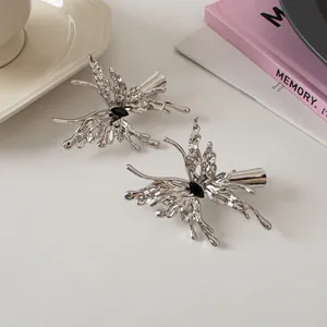 Detailed macro view of liquid metal butterfly hair clip with black rhinestone inlay