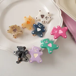 Detail of colorful bear hair clips with heart accents in eight different vibrant colors