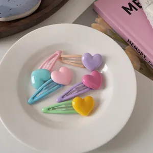 Set di 5 mollette per capelli a forma di cuore color pastello in un piatto di ceramica