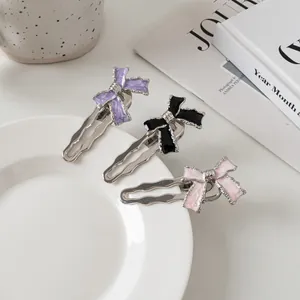 Set van drie Y2K metalen strik haarclips in paars, zwart en roze met marmeren textuur look