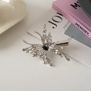 Macro detail of liquid silver butterfly hair clip with a black marquise stone
