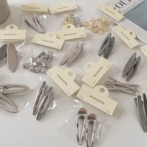 Minimalistische Haarspangen aus gebürstetem Metall in Silber und Gold auf Karton