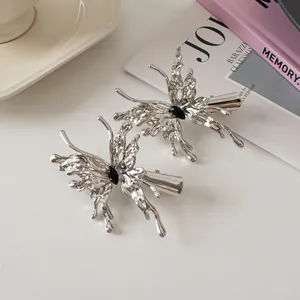 Detail of silver liquid metal butterfly hair clips with black marquise gemstones