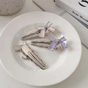 Detail van roze en paarse marmeren strik haarspelden met zilveren golvend metaalontwerp