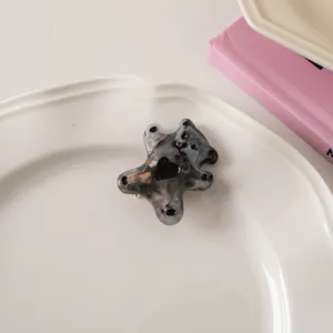 Detail of bear hair claw with marble texture and heart accent on a white ceramic plate