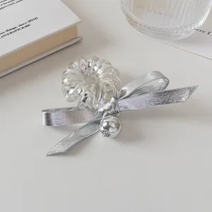 Détail d'un chouchou nœud argenté avec cordon spirale transparent et perle métallique