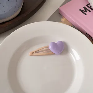 Dettaglio di un dolce fermaglio per capelli a forma di cuore su un piatto di ceramica bianco