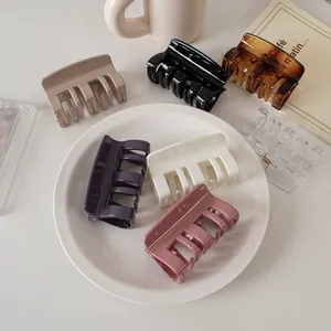 Macro shot of assorted cream colored square hair claws in a minimalist French setting