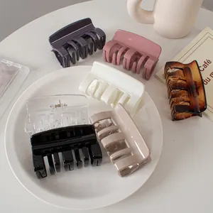 Detail of medium square hair claws in assorted glossy colors on a ceramic tray
