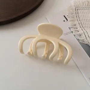 Minimalistische cremeweiße Haarklammer glänzend auf einem eleganten ästhetischen Hintergrund