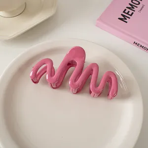 Nahaufnahme der tiefrosa gewellten Haarklammer auf weißem Tablett im minimalistischen Stil