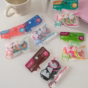 Close-up of candy-colored elastic hair ties in pastel packaging with cute girl illustration