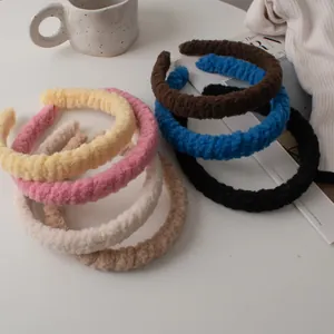 Gros plan de serre-têtes en peluche déclinés en tons crème et terre sur tricot