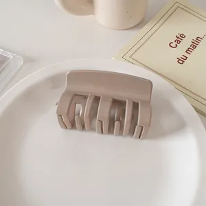 Glossy cream medium square hair claw clip displayed on a white plate with aesthetic decor