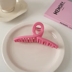 Detailansicht der glänzend rosa gewellten Haarklammer auf einem Keramikteller