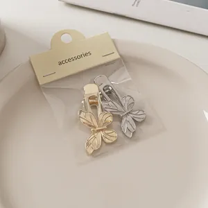 Detail von goldenen und silbernen Schmetterlings-Haarspangen mit gebürsteter Metallstruktur