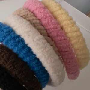 Détail de serre-têtes en peluche épaisse en sept couleurs dont crème, bleu et brun