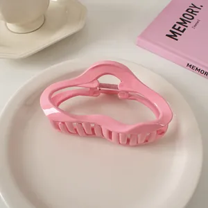 Nahaufnahme der rosa Wellen-Haarklammer mit glänzender Oberfläche und Metallfeder