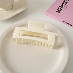 Detail einer cremefarbenen matten Haarklammer mit hohlem geometrischem Design für Haar