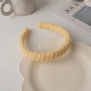 Gros plan sur un serre-tête en peluche crème duveteuse sur une assiette décorative d'hiver
