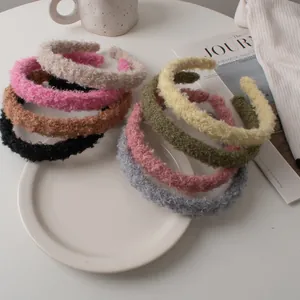Detailed close-up of colorful faux lamb wool headbands set in soft textured plush fabric