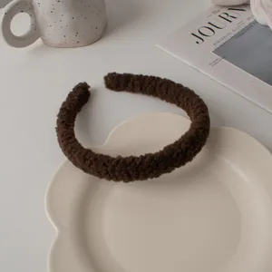 Gros plan d'un serre-tête en peluche marron foncé sur une assiette en céramique
