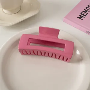 Glänzende rose-pinkfarbene rechteckige Haarklammer auf einem Keramikteller serviert