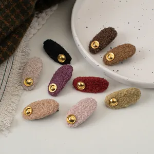 Retro wool hair clips with gold label in various candy colors on a ceramic tray