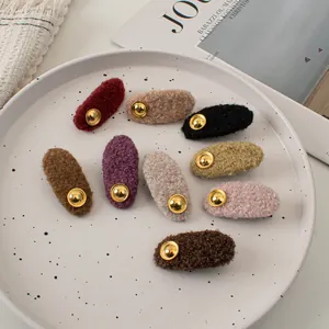 Detailed set of 9 colorful teddy fleece hair clips with vintage golden buttons in a ceramic tray