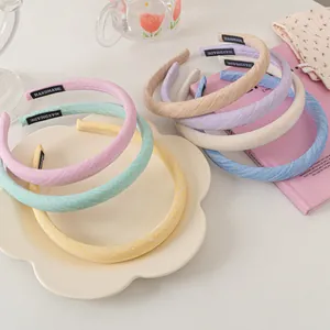 Macro detail of pastel fabric headbands showing fine twill texture and handmade label