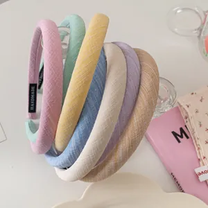 Morandi fabric headbands in assorted colors displayed on a glass rack for summer fashion
