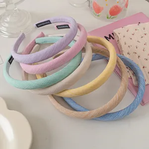 Detailed close-up of handmade fabric headbands with woven label in pastel colors